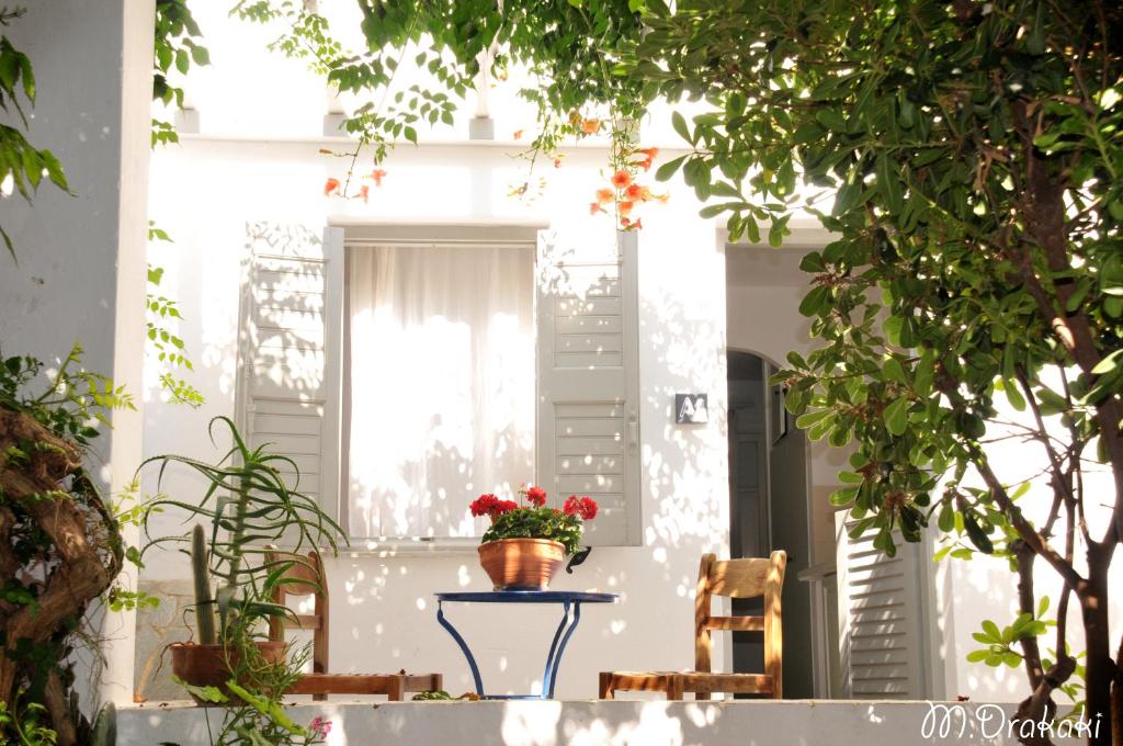 un vaso da fiori su un tavolo di fronte a una casa di Aegean Village a Paroikia