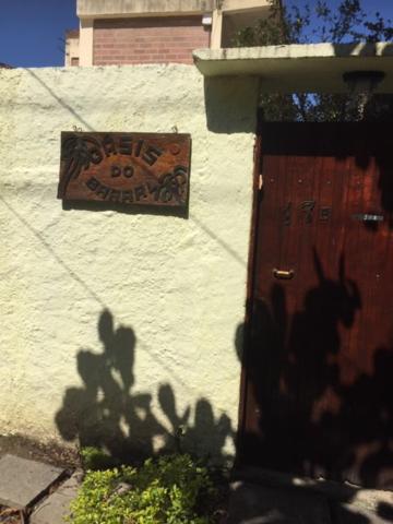 um sinal na lateral de um edifício ao lado de uma porta em Pousada OASIS DO BARRAL no Rio de Janeiro