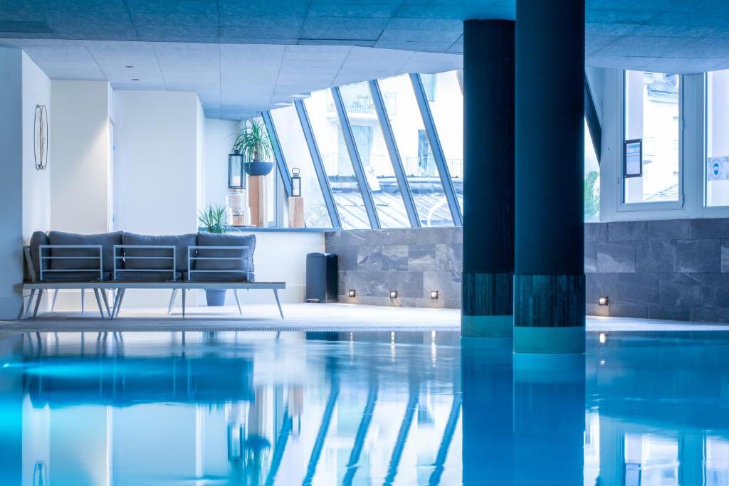 a living room with a pool and a couch at Garden & City Cauterets Balneo in Cauterets