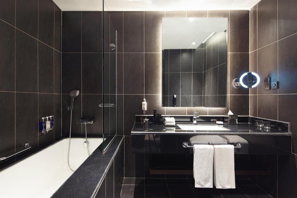 a bathroom with a sink and a mirror at Dukes The Palm Dubai Hotel in Dubai