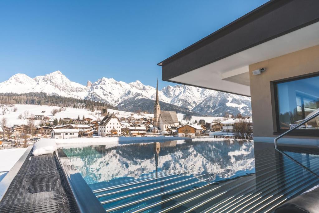 a balcony with a view of a snowy mountain at die HOCHKÖNIGIN - Mountain Resort in Maria Alm am Steinernen Meer