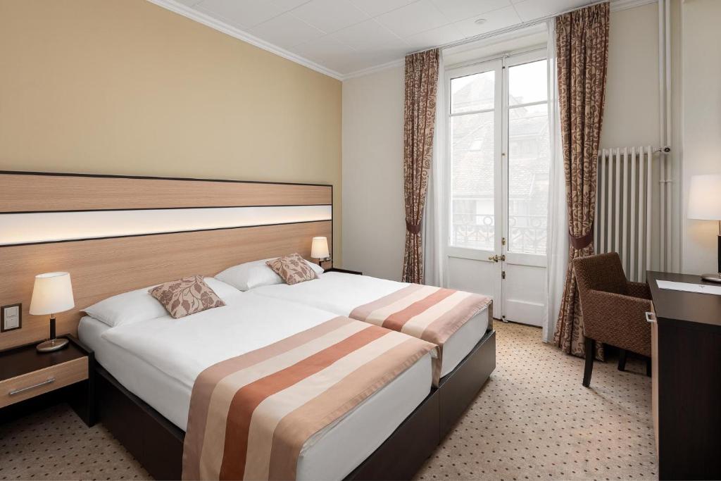 Postel nebo postele na pokoji v ubytování Hôtel des Alpes