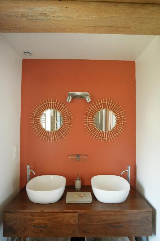 a bathroom with two sinks and two mirrors on a wall at Le Domaine de l&#39;Hostellerie in Le Fresne-Camilly