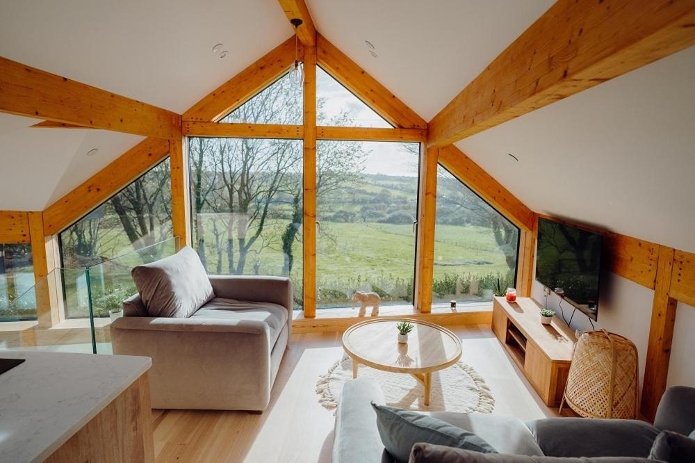 a living room with a couch and a table at Beavers Lodge. Luxury Property with Hot Tub in Tenby