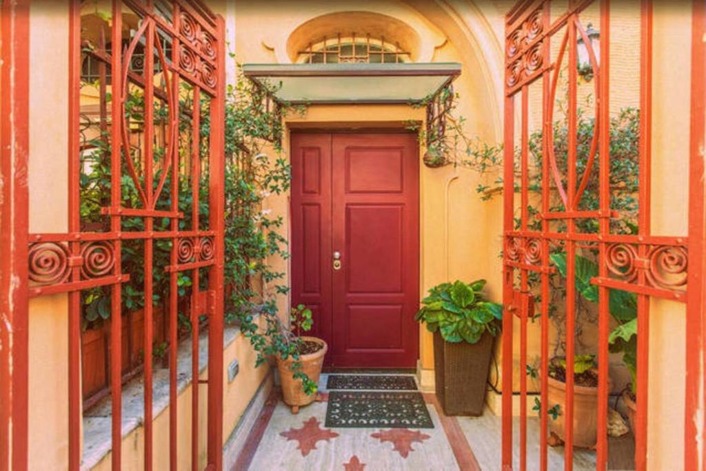 a red door on a building with plants at Aldebaran in Rome