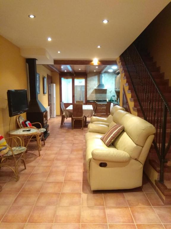 a living room with a couch and a staircase at Casa Costeta in Cinctorres