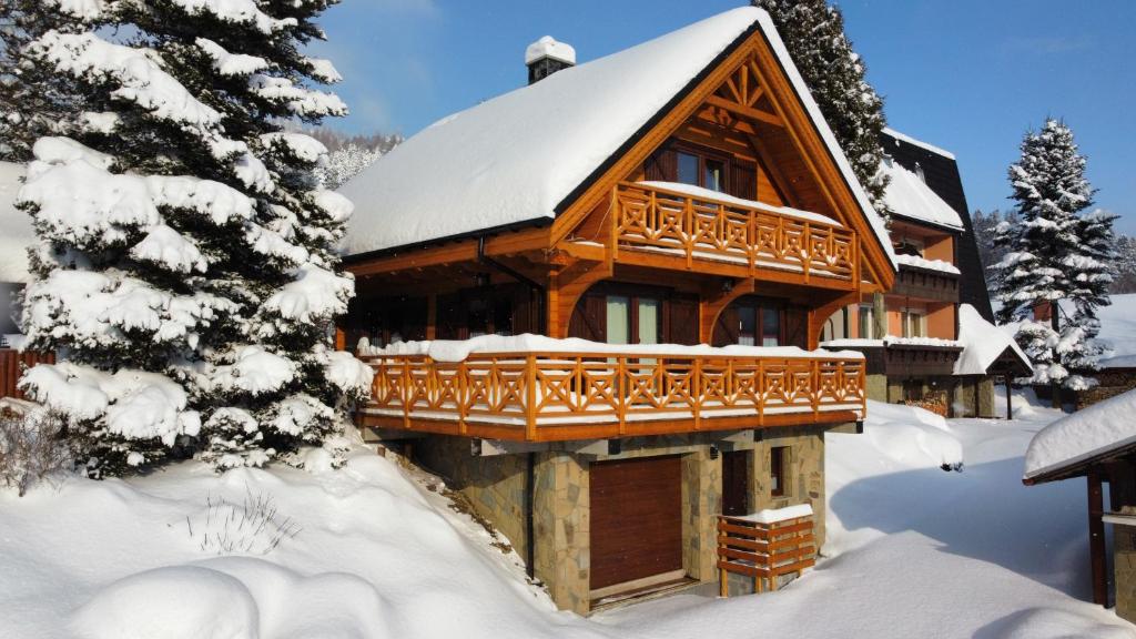 une cabane en rondins dans la neige avec des arbres enneigés dans l'établissement Domek Góralska Nuta, à Szczyrk