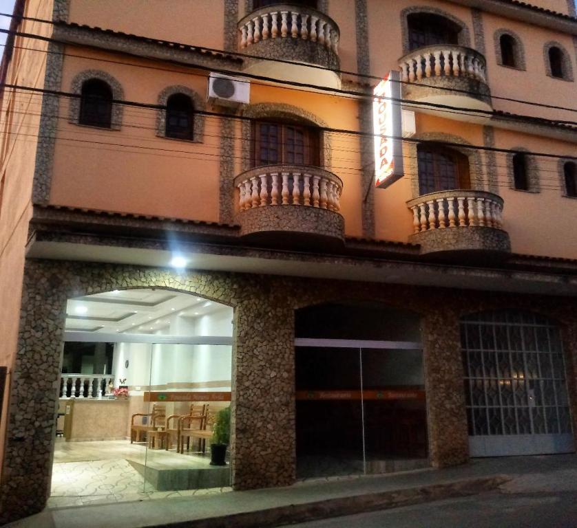 a tall building with a building with a window at Pousada Moura Ávila in Dores de Campos