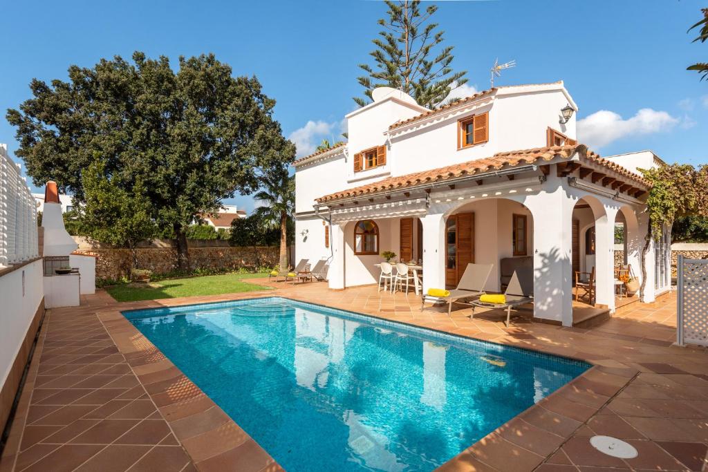 a villa with a swimming pool in front of a house at Villa Elena by Mauter Villas in Cala en Blanes