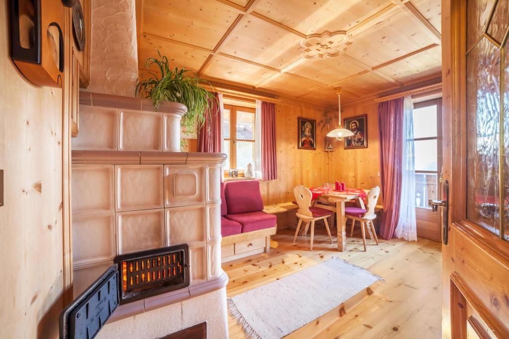 a living room with a fireplace and a table at Hoferhof Apartement Bergspitze in Schenna