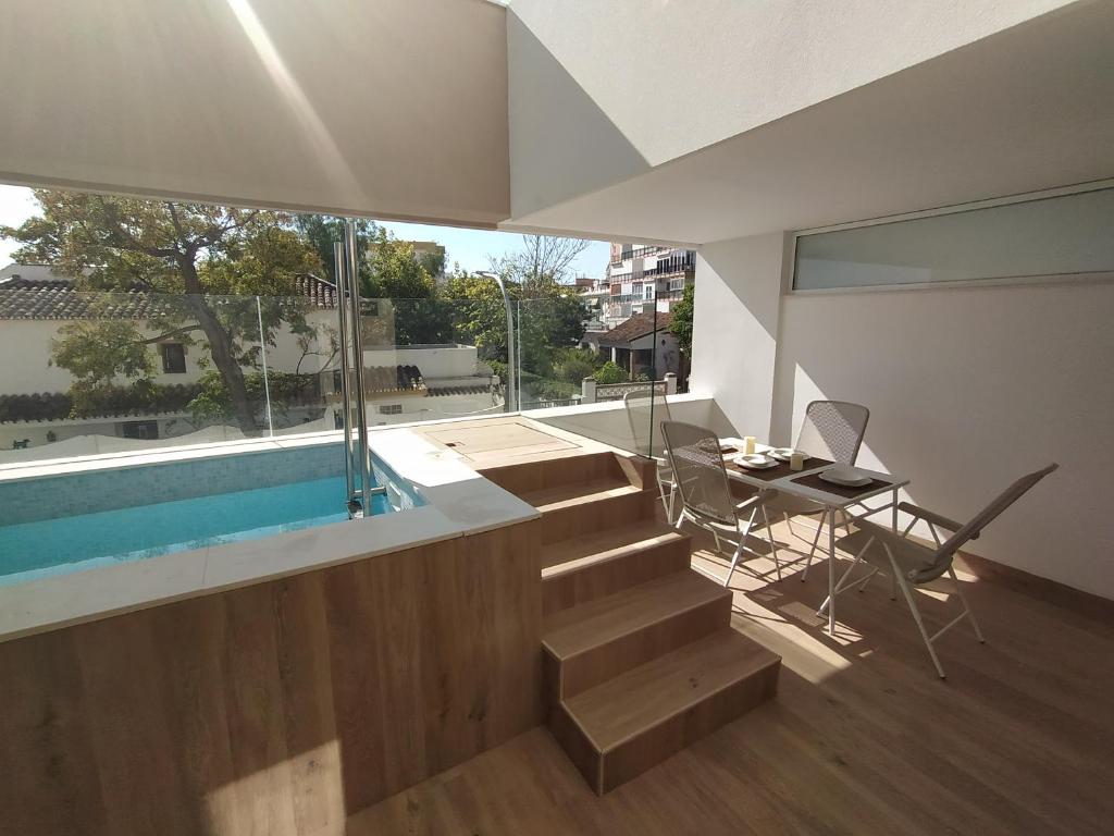 ein Haus mit einem Pool, einem Tisch und einer Treppe in der Unterkunft APARTAMENTO TERRAZAS DEL MAR, PISCINA PRIVADA in Torremolinos