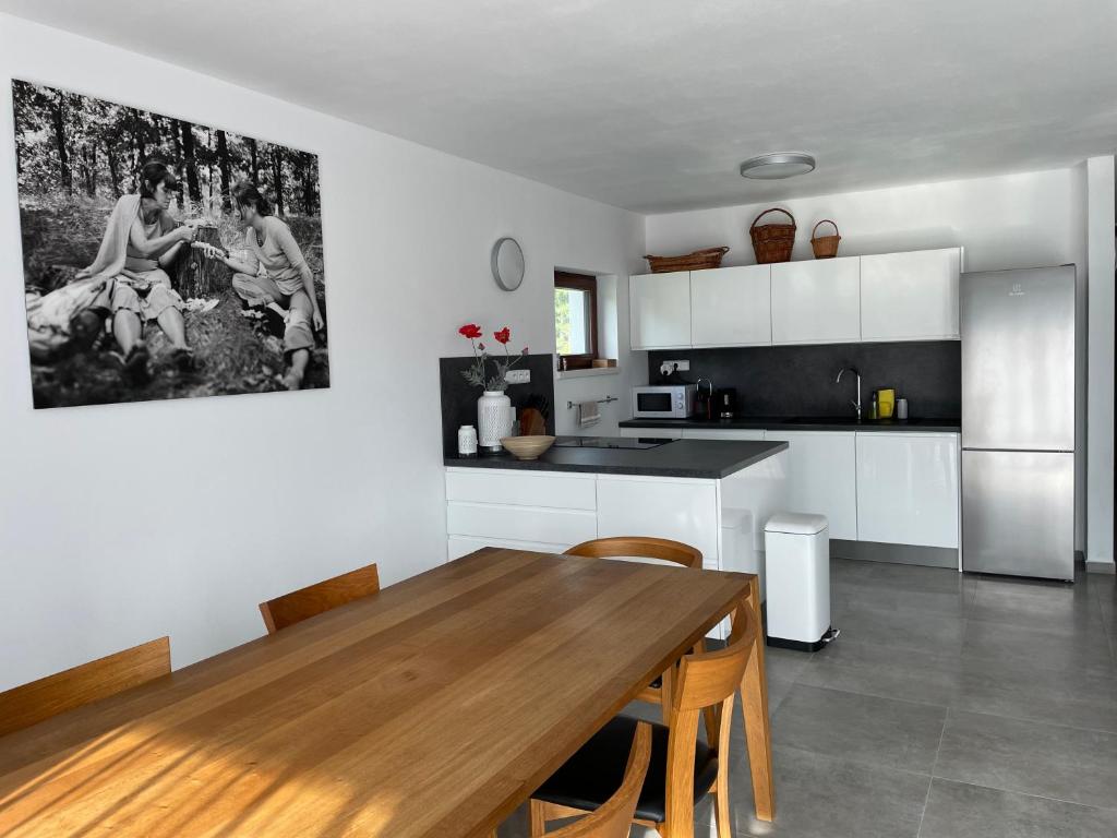 uma cozinha com uma mesa de madeira e uma sala de jantar em Free Spirit em Nová Pec