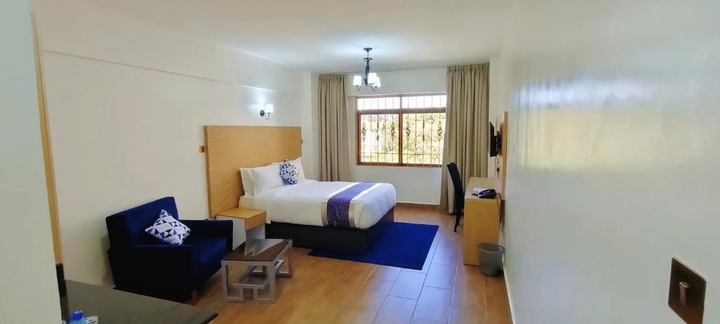 a hotel room with a bed and a chair at Hays Suites Hotel in Nairobi