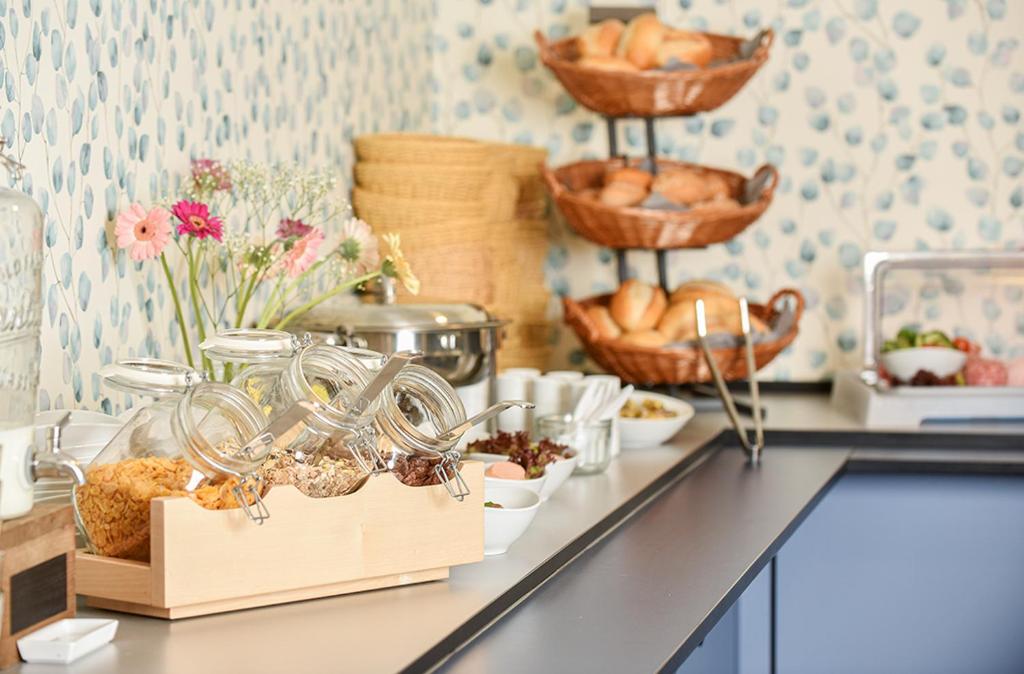 a kitchen counter with bowls of food and other foods at PRIMA Inn HOTEL & HOF NEURUPPIN - digitales & rezeptionsloses Motel in Neuruppin