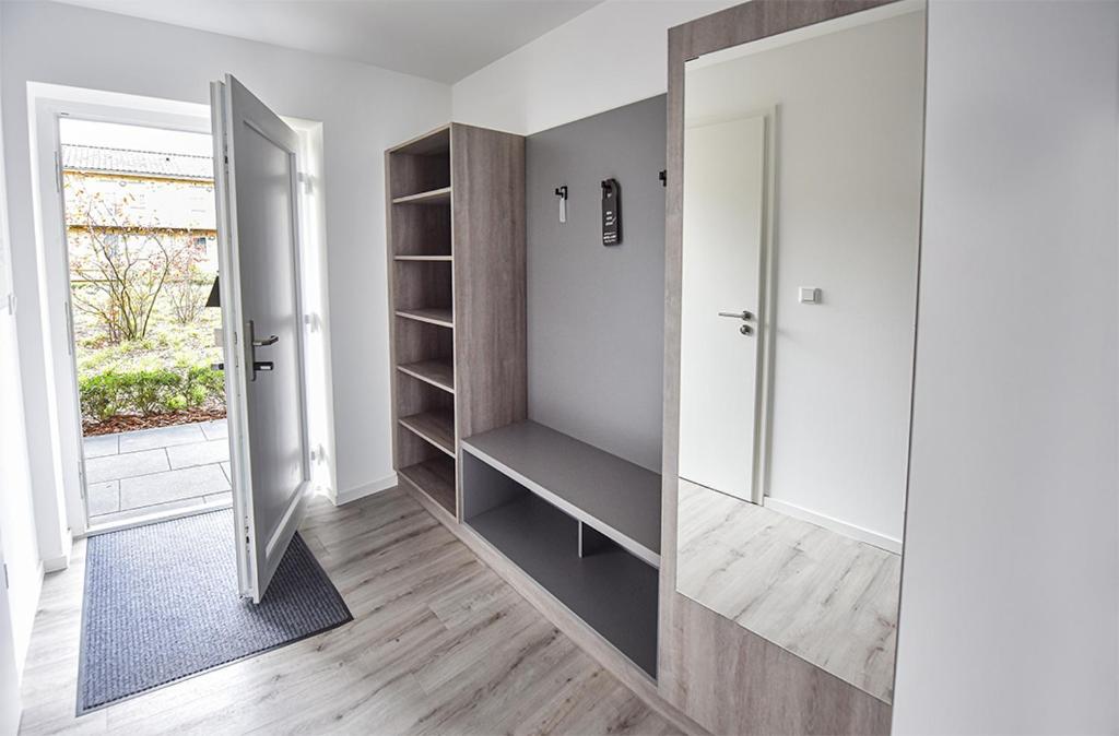 a hallway with a walk in closet and a mirror at PRIMA Inn HOTEL & HOF NEURUPPIN - digitales & rezeptionsloses Motel in Neuruppin