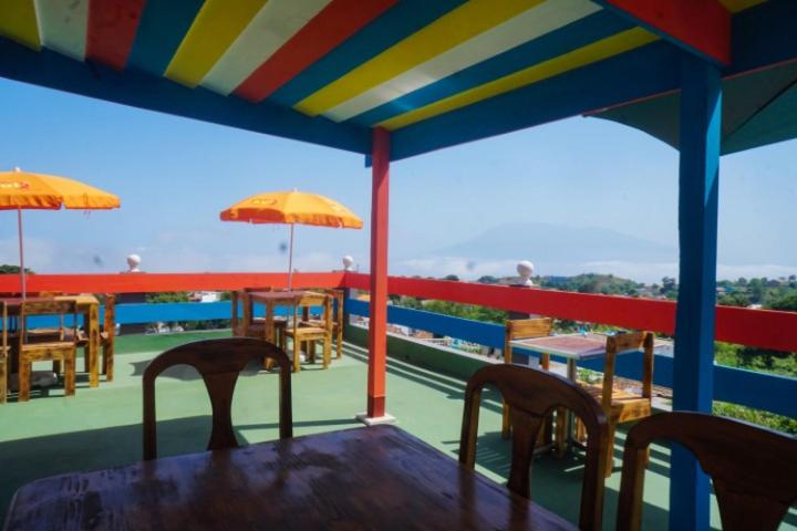 a table with chairs and umbrellas on a deck at Hotel 3M Tours in Vila Nova Sintra
