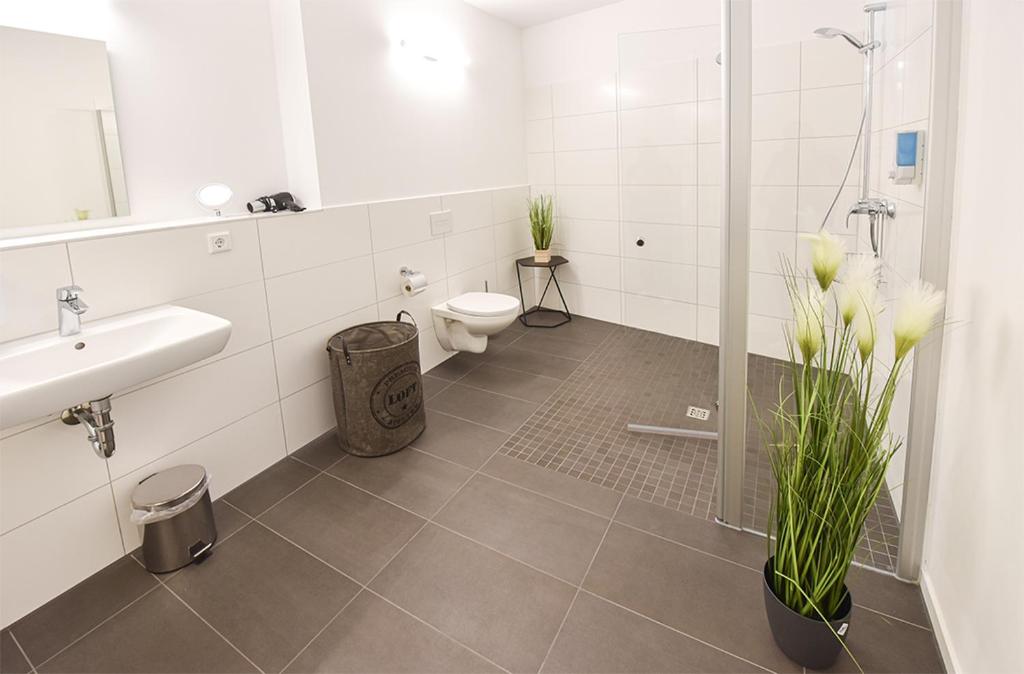a bathroom with a toilet and a sink and a shower at PRIMA Inn HOTEL & HOF NEURUPPIN - digitales & rezeptionsloses Motel in Neuruppin