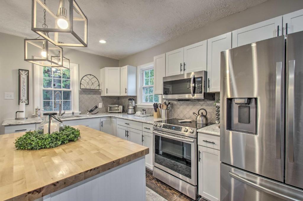 a kitchen with white cabinets and a stainless steel refrigerator at Renovated Lynchburg House about 2 Mi to Downtown! in Lynchburg