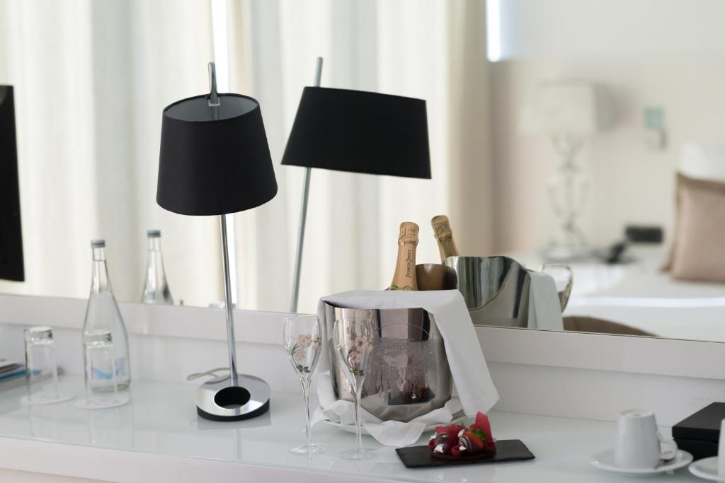 a white table with a lamp and a wine glass at Farol Hotel in Cascais