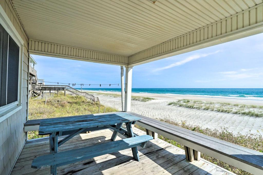 a porch with a picnic bench on the beach at Peaceful Cottage By The Sea Oceanfront Home! in Surf City