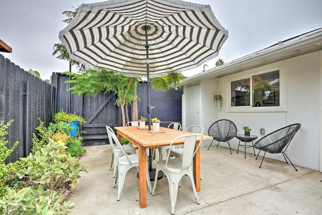 a wooden table with chairs and an umbrella on a patio at Chic and Central Ventura Home - Walk to Beach! in Ventura