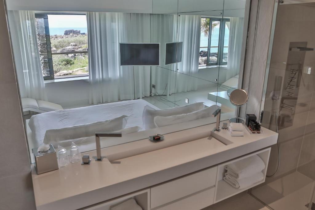 a bathroom with a large mirror and a sink at Farol Hotel in Cascais