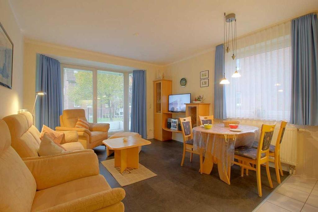 een woonkamer met een tafel en een eetkamer bij KD12 48 Kajediek in Dorum Neufeld