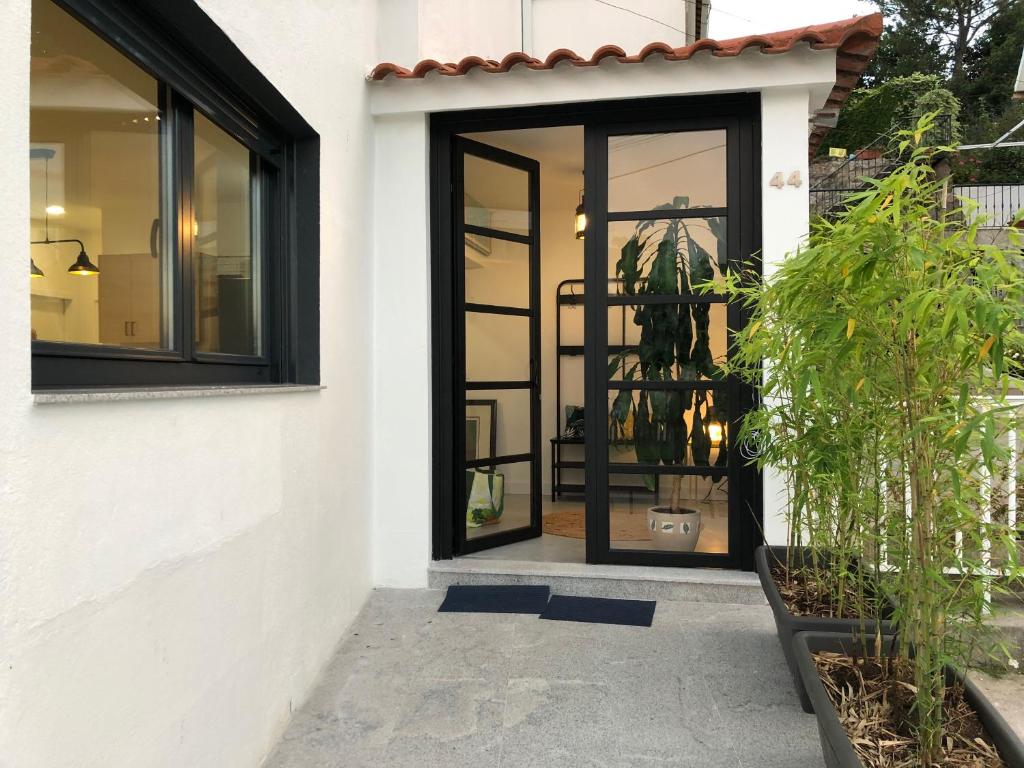 una porta girevole in una casa bianca con finestre nere di Casa Arealonga a Vigo
