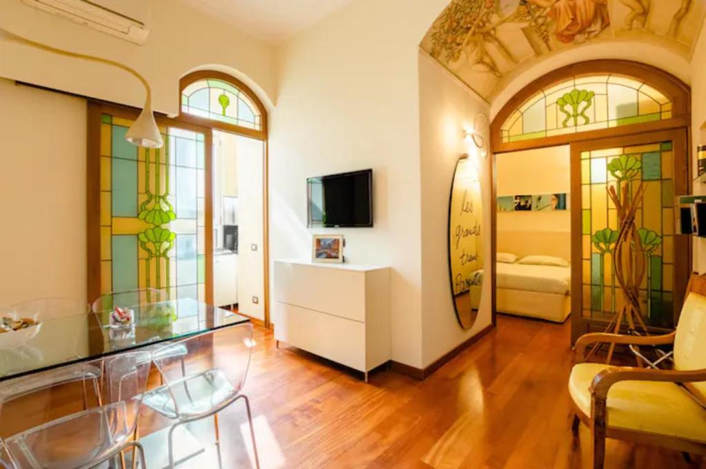 La Petite Maison Piave في روما: غرفة معيشة مع نوافذ زجاجية ملطخة وتلفزيون
