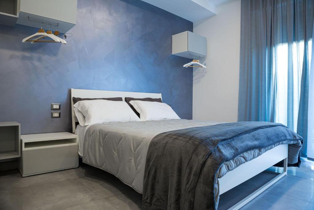 a bedroom with a bed and a blue wall at Amica geniale in Naples