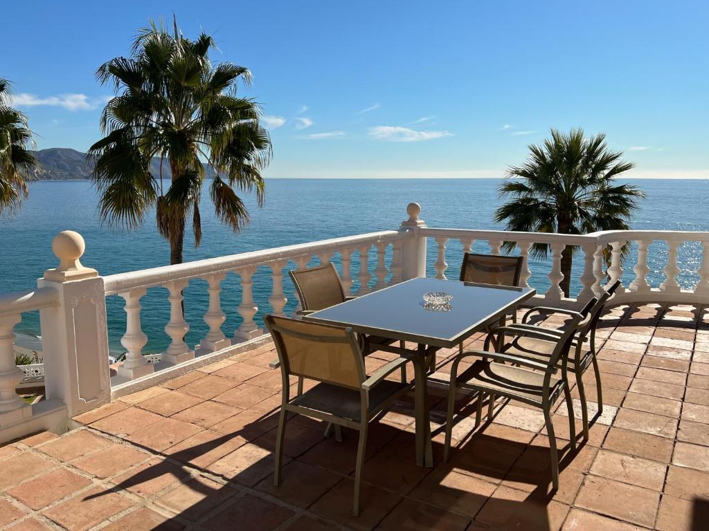 a table and chairs on a balcony overlooking the ocean at Hotel Paraíso Del Mar in Nerja