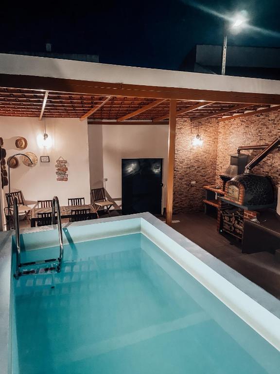 a swimming pool at night in a room with a brick wall at Casinha do Roxo in Ervidel