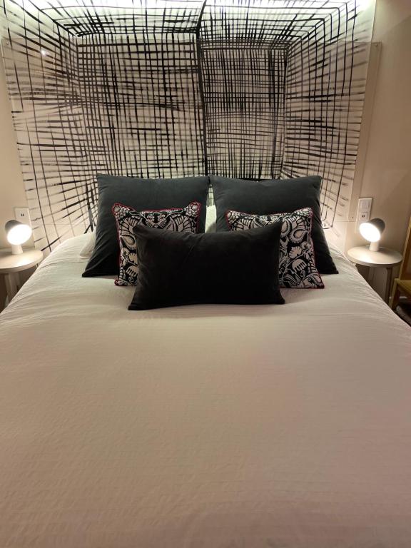 une chambre avec un grand lit blanc avec des oreillers dans l'établissement Maison Terrasse Beauduc, Arles, à Arles