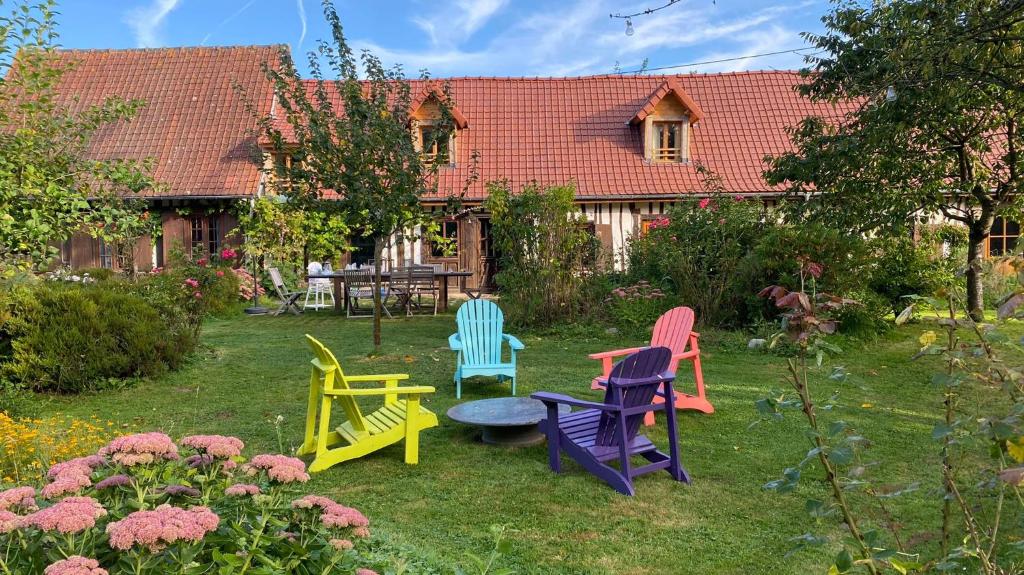 un groupe de chaises assises dans une cour dans l'établissement La Lanterne: Grande maison à deux pas de la mer, à La Chapelle-sur-Dun