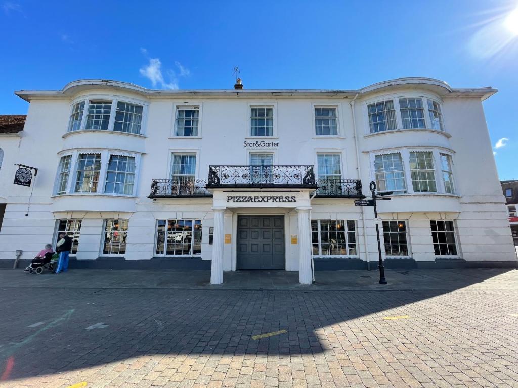a white building with a balcony on top of it at The Star and Garter Hotel in Andover