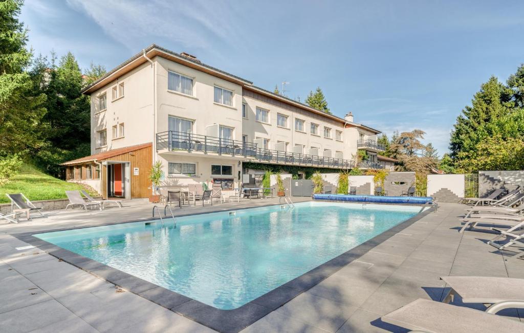 une grande piscine en face d'un bâtiment dans l'établissement Logis Hotel Maison Carrée Restaurant O Carré dArt, à Méréville