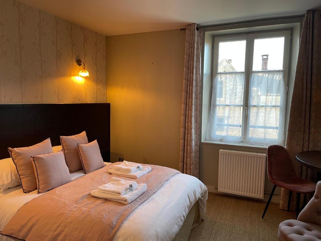 um quarto de hotel com uma cama com toalhas em Auberge du Chasseur em Grosrouvre