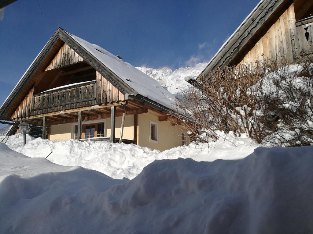 ein schneebedecktes Haus davor in der Unterkunft Feriendorf Stodertraum in Gröbming