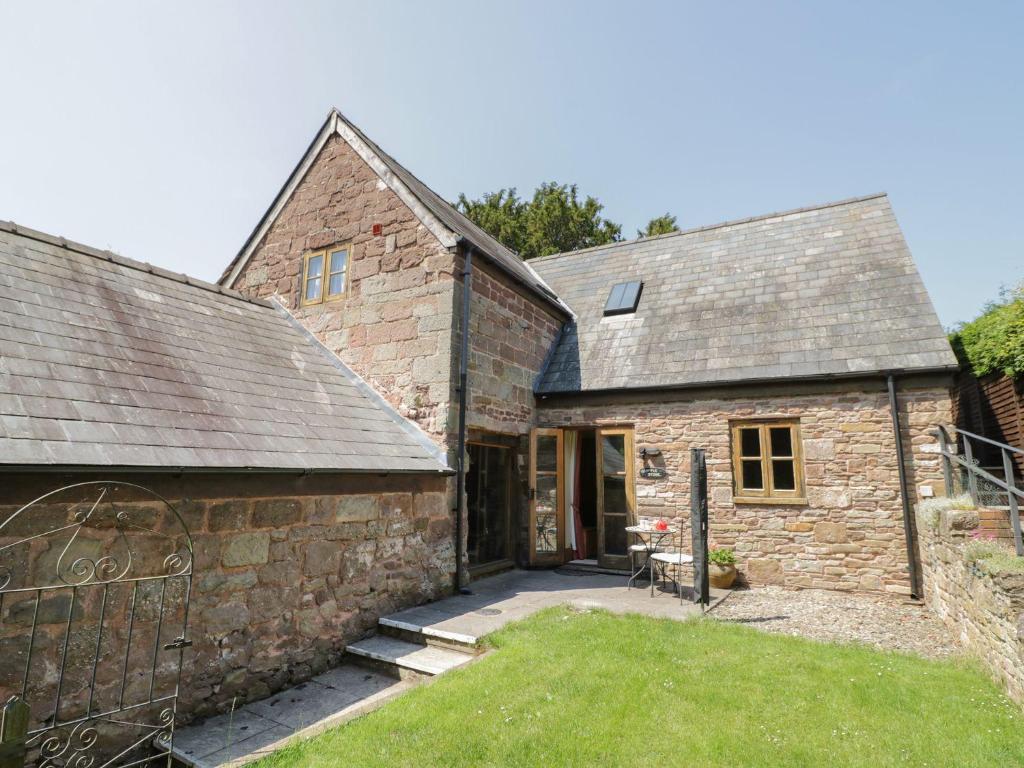 an external view of a stone building with a courtyard at The Apple Store in Ross on Wye