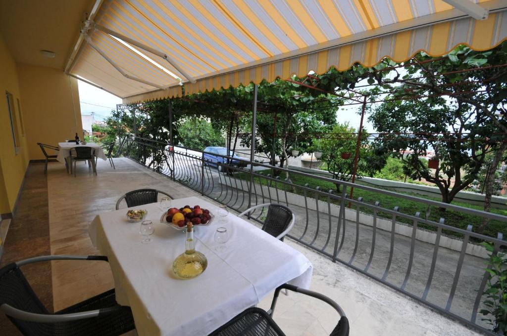 una mesa blanca con un bol de fruta en el balcón en Apartments Marinko, en Trogir