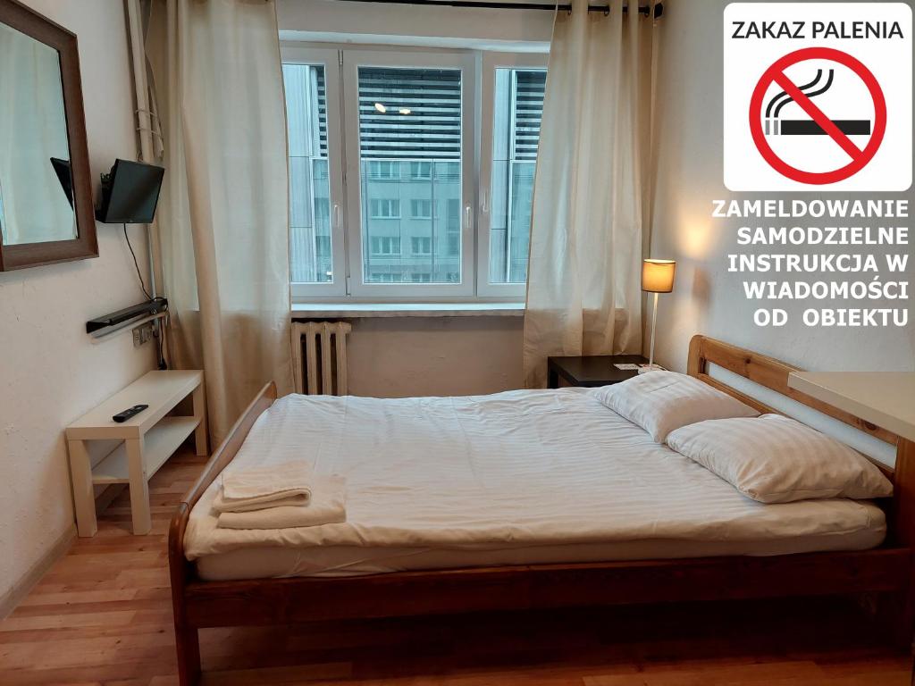 ein Schlafzimmer mit einem Bett mit einem Nichtraucherschild in der Unterkunft NEXT TIME in Warschau