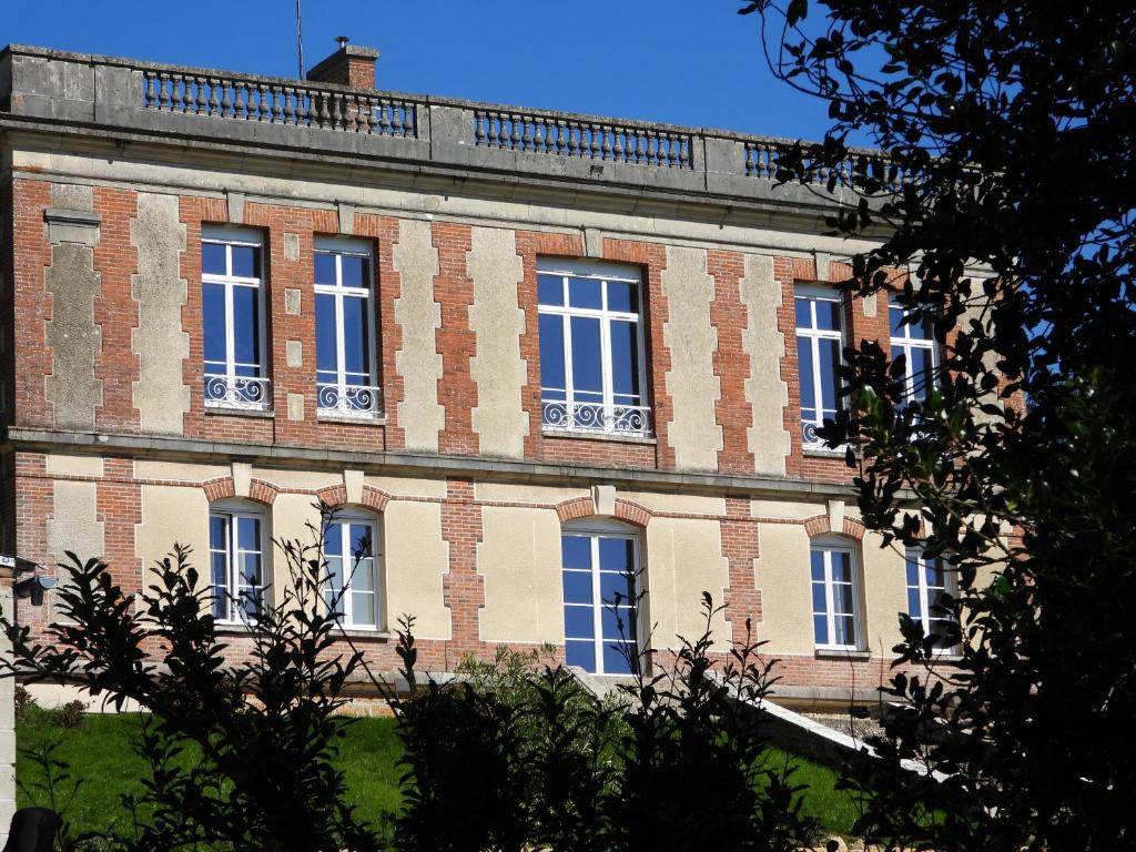 ein großes Backsteingebäude mit vielen Fenstern darauf in der Unterkunft Demeure de la Garenne in Montmirail