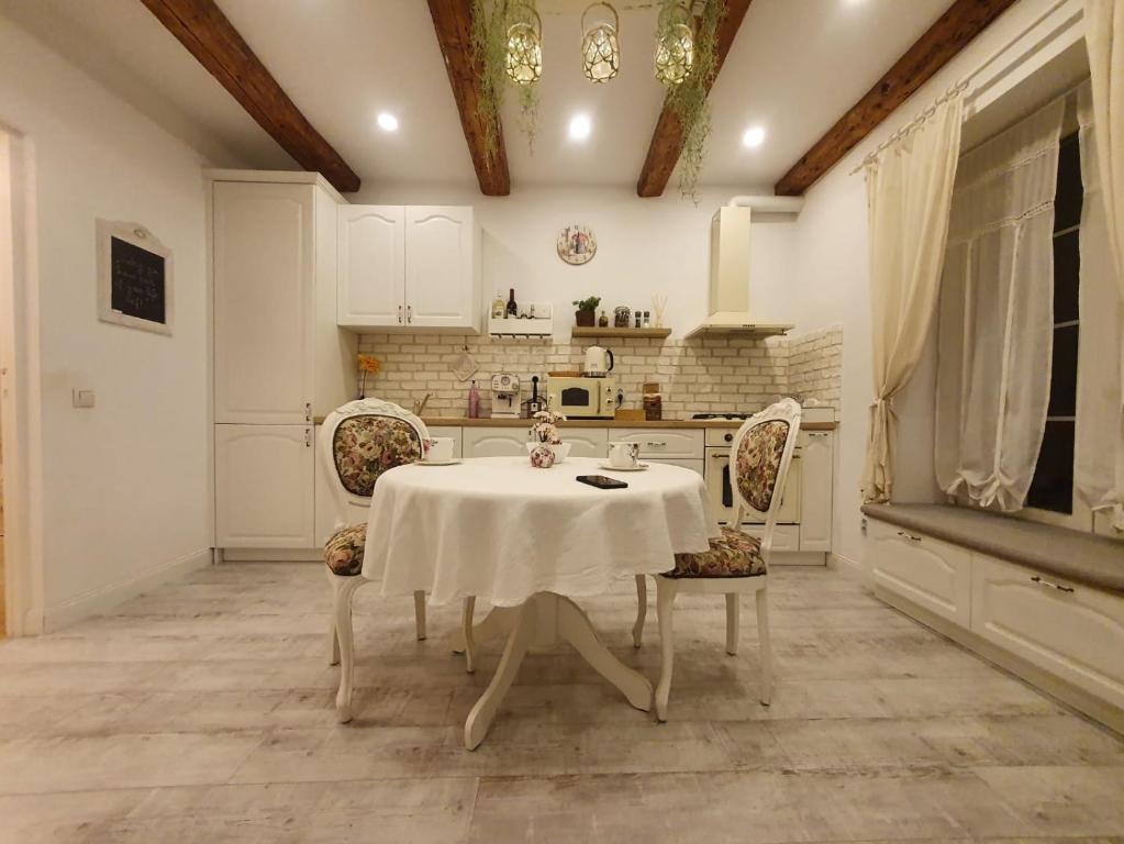 Avram Iancu Apartment في كلوي نابوكا: مطبخ مع طاولة وكراسي في غرفة