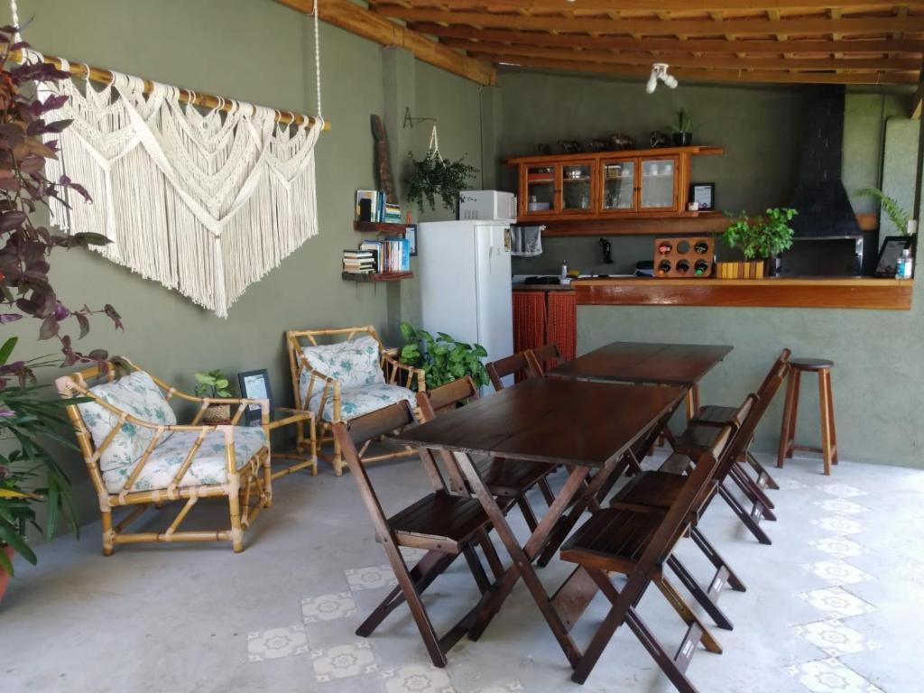 a dining room with a table and chairs and a kitchen at Terral Casa de Praia in Guarujá