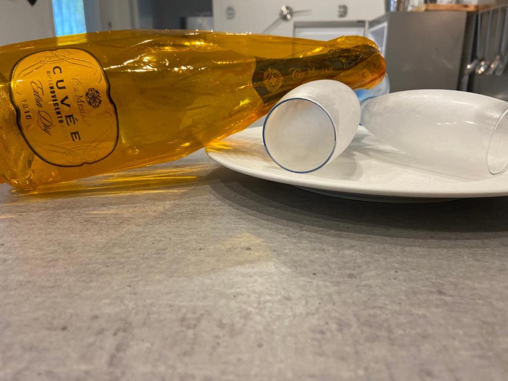 a bottle of wine sitting next to a plate with a cup at Bari Lory’s Home in Bari