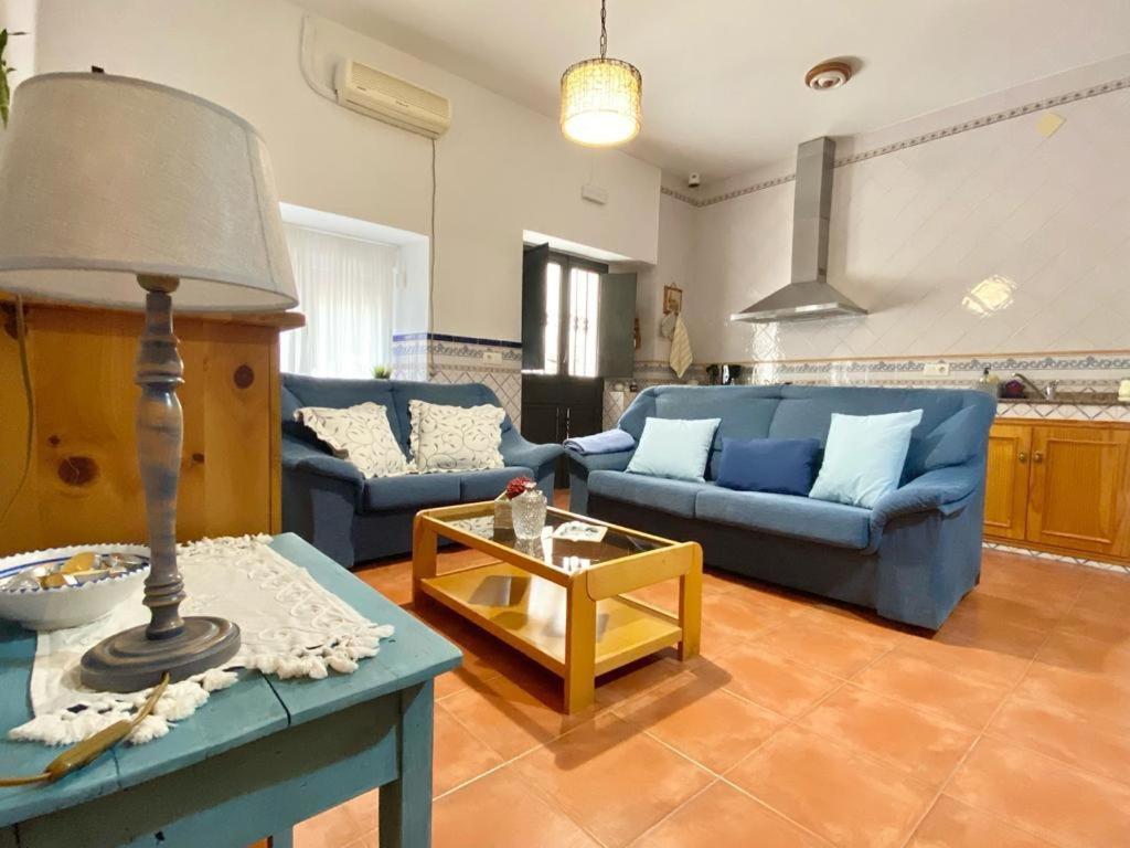 uma sala de estar com um sofá azul e uma mesa em Casa Rural La abuela em El Campo