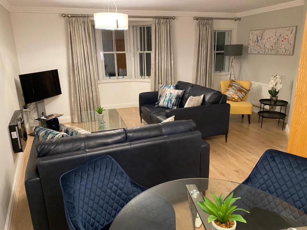 a living room with a black leather couch and chairs at GS - Luxury, modern town centre, 2 beds, free parking for one vehicle in Stratford-upon-Avon