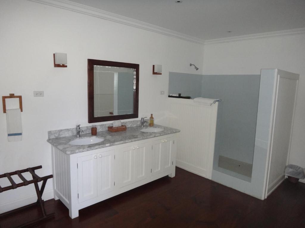 a white bathroom with two sinks and a mirror at The Atlantis Historic Inn in Saint Joseph
