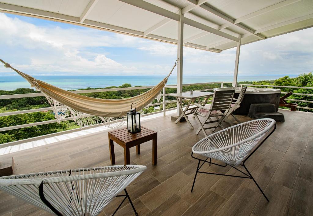 a hammock on a balcony with a view of the ocean at Funky Monkey Lodge in Santa Teresa Beach