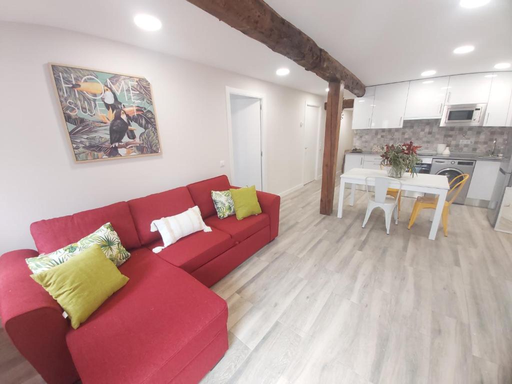 a living room with a red couch and a table at El Rincón Del Marques Alojamientos con encanto centro turístico in Logroño